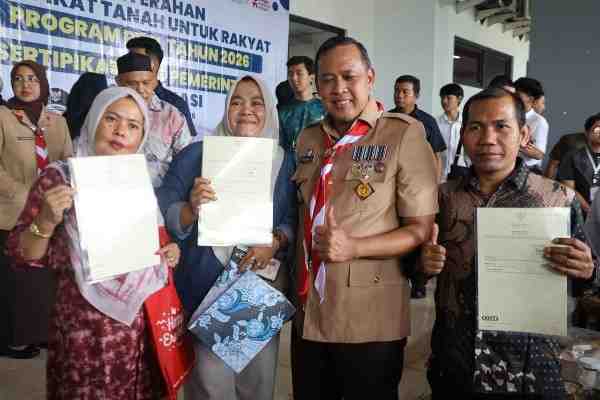 Wali Kota Bekasi Tri Adhianto menyerahkan sertifikat tanah PTSL 2026 secara simbolis di Stadion Patriot Candrabhaga.