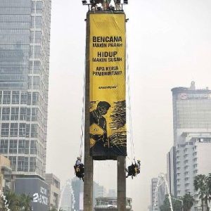 Aktivis Greenpeace Indonesia bentangkan spanduk raksasa Tangani Krisis Iklim di Patung Selamat Datang Bundaran HI Jakarta