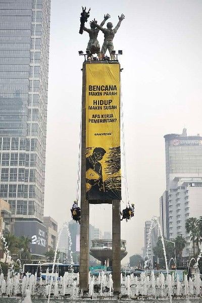 Aktivis Greenpeace Indonesia bentangkan spanduk raksasa Tangani Krisis Iklim di Patung Selamat Datang Bundaran HI Jakarta