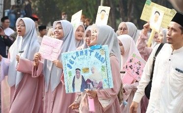 Peserta pawai memegang spanduk Semarakkan Acara Pawai Hari Santri Kota Bekasi 2026.